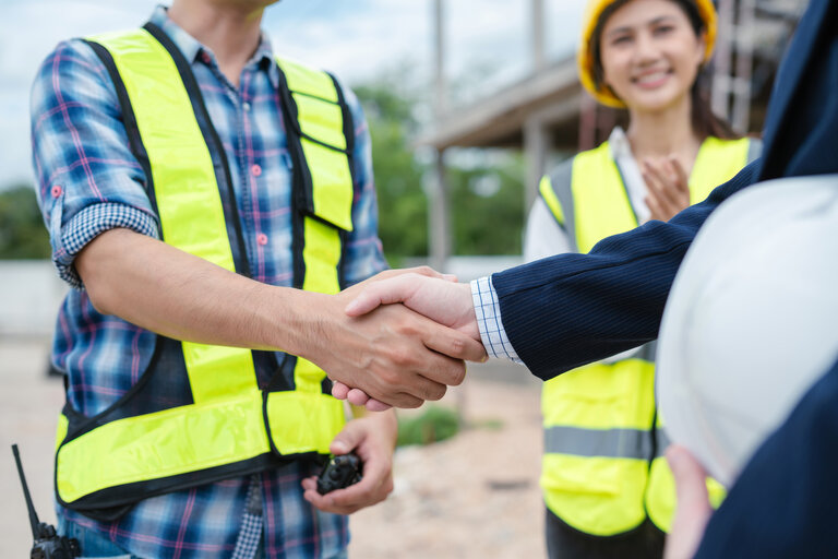 construction worker and contractor. Client shaking hands with team builder in renovation site in the morning.